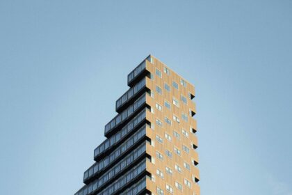 Tall residential condo apartment building with many windows against blue sky