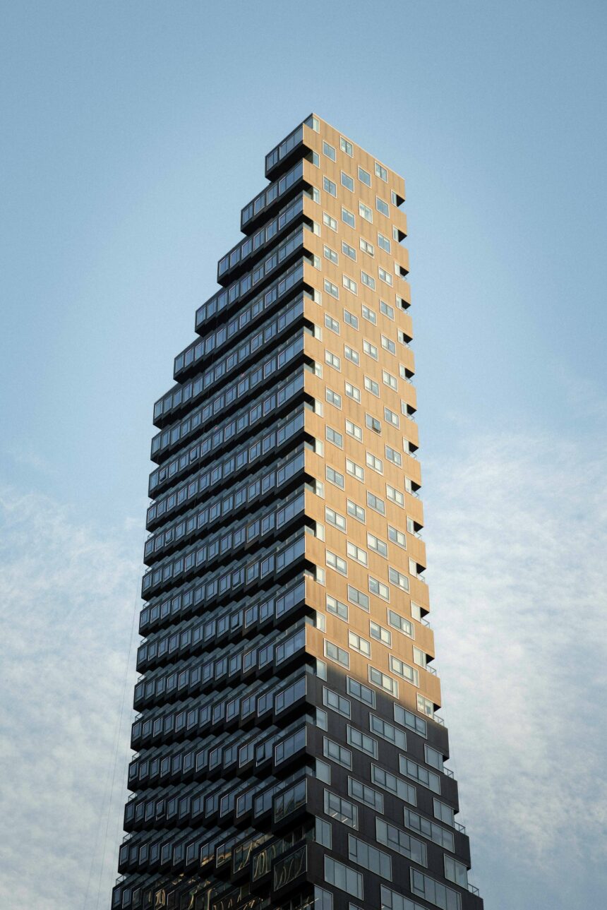 Tall residential condo apartment building with many windows against blue sky