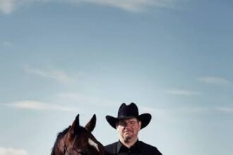 Scott Hardy standing with a horse in the Alberta foothills near Longview