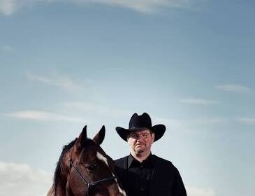 Scott Hardy standing with a horse in the Alberta foothills near Longview