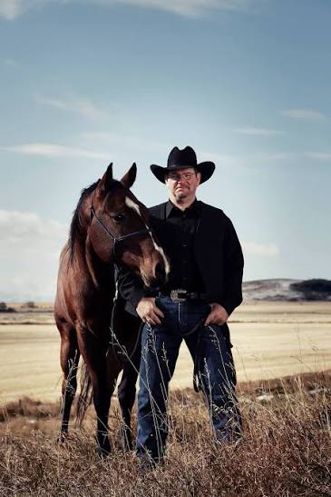 Scott Hardy standing with a horse in the Alberta foothills near Longview