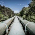Aboveground natural gas pipeline running through a forest corridor