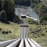 Sections of large diameter pipeline laid out across an open field