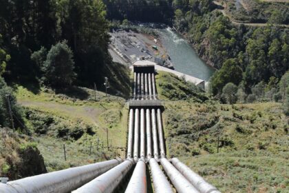 Sections of large diameter pipeline laid out across an open field