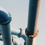 Large industrial pipeline valve and steel piping against an open sky