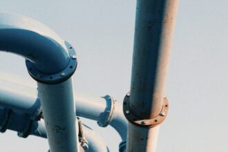 Large industrial pipeline valve and steel piping against an open sky