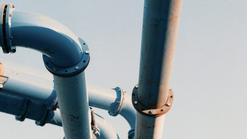 Large industrial pipeline valve and steel piping against an open sky