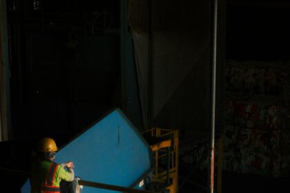 Worker sorting material at a recycling facility