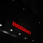 Red emergency sign lit at a building entrance at night