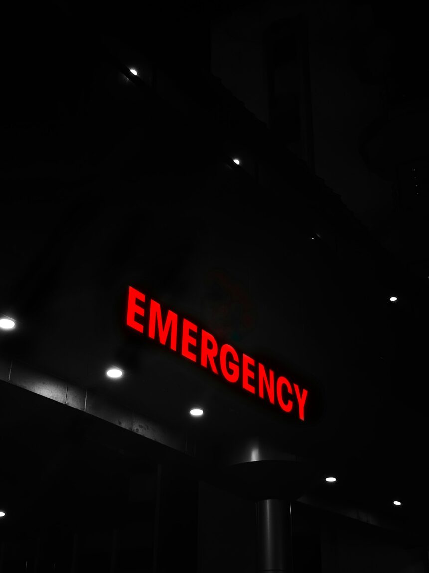 Red emergency sign lit at a building entrance at night