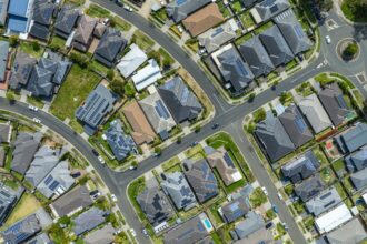 Aerial view of a suburban neighbourhood where many house roofs carry solar panels