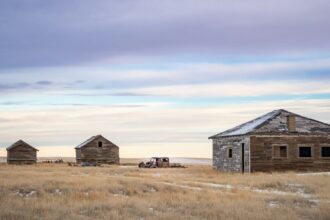 Old farm buildings standing in an open Alberta field