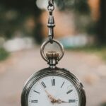 An antique railway pocket watch resting on a weathered surface