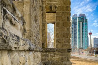 Weathered sandstone wall in Calgary with the Calgary Tower and downtown towers beyond