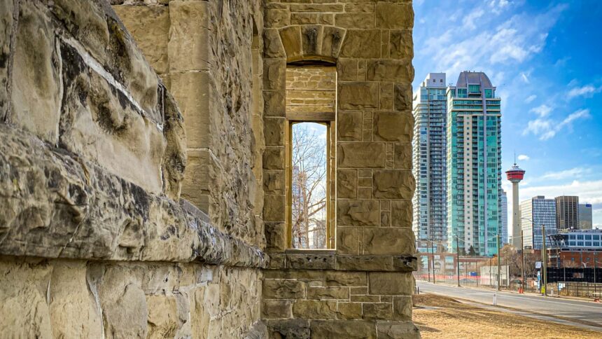 Weathered sandstone wall in Calgary with the Calgary Tower and downtown towers beyond