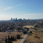 An aerial view across Calgary neighbourhoods toward the downtown skyline