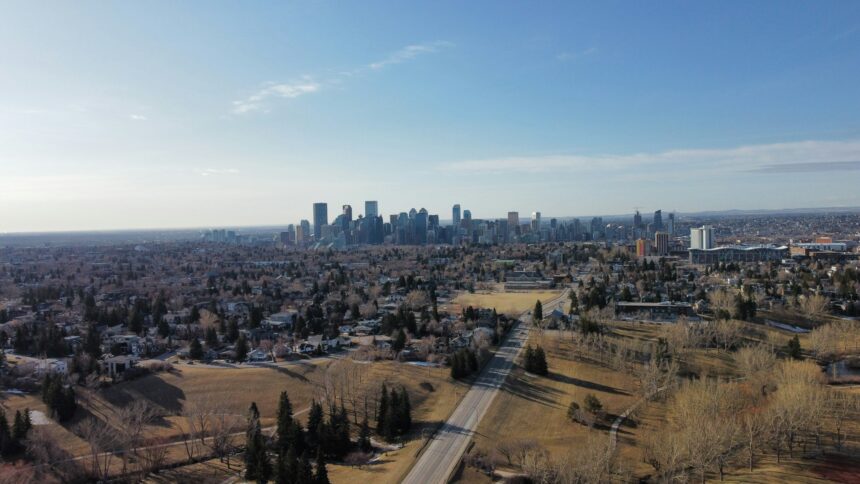 An aerial view across Calgary neighbourhoods toward the downtown skyline