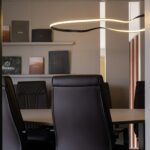 A modern conference room with a long table and leather chairs