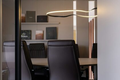 A modern conference room with a long table and leather chairs