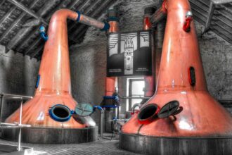 Two copper pot stills in a distillery