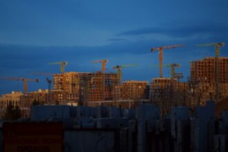 Tower cranes over wood-frame apartment buildings under construction