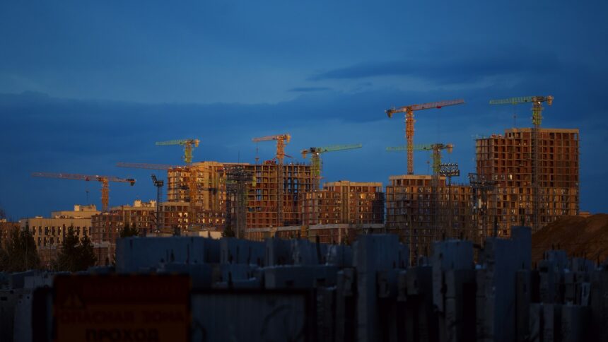 Tower cranes over wood-frame apartment buildings under construction