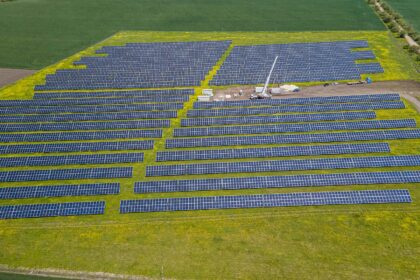 A solar array on farmland beside an industrial site