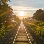 Railway track running toward the horizon at low sun