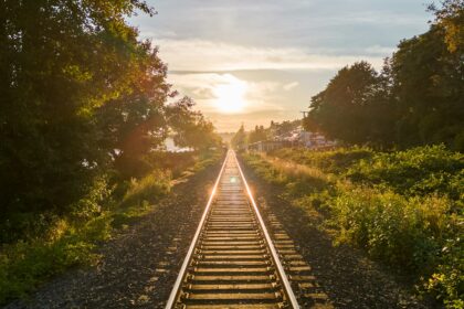 Railway track running toward the horizon at low sun