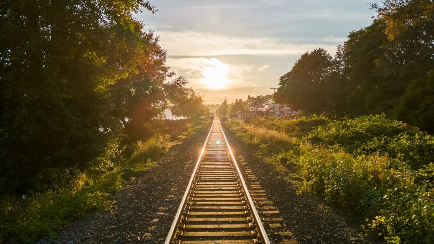 Railway track running toward the horizon at low sun