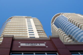 Curved residential condo towers against a blue sky in Edmonton