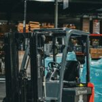 A forklift parked inside a warehouse stacked with palletised goods