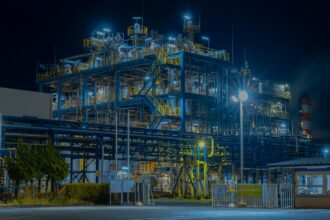 A large industrial gas processing plant lit up after dark