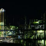 A gas processing complex with towers and piping lit up at night