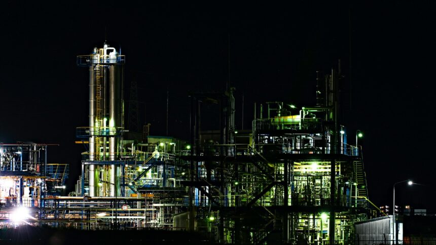 A gas processing complex with towers and piping lit up at night