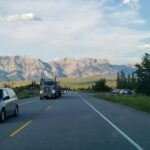 Cars and a truck on a highway near Jasper with mountains behind