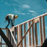 A construction worker on the wood frame of a new home