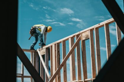 A construction worker on the wood frame of a new home