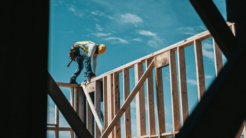 A construction worker on the wood frame of a new home