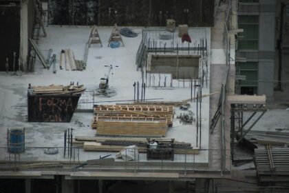 A snowy construction site with idle materials and equipment