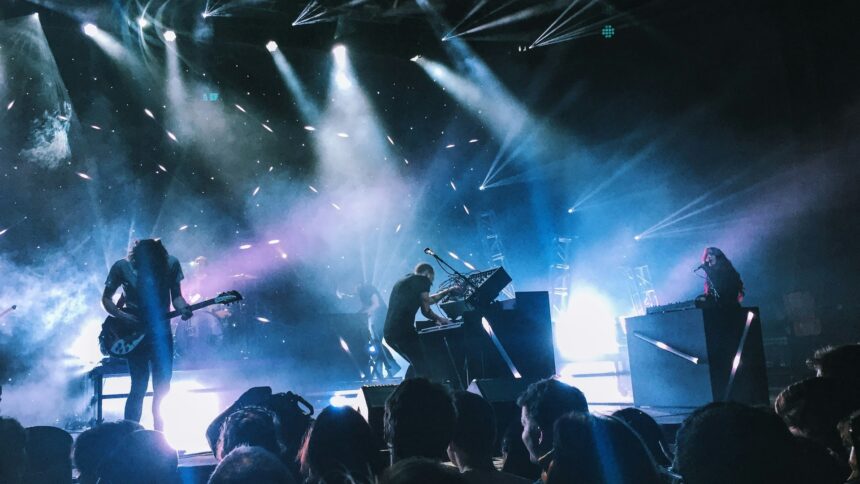 A band performing on a lit stage in front of an audience
