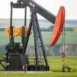 An oil pumpjack in a green field in central Alberta