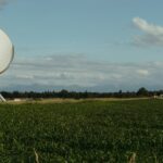 A satellite dish mounted beside a field in open farm country