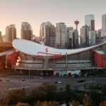 Aerial view of the Scotiabank Saddledome curved roof with the Calgary skyline behind