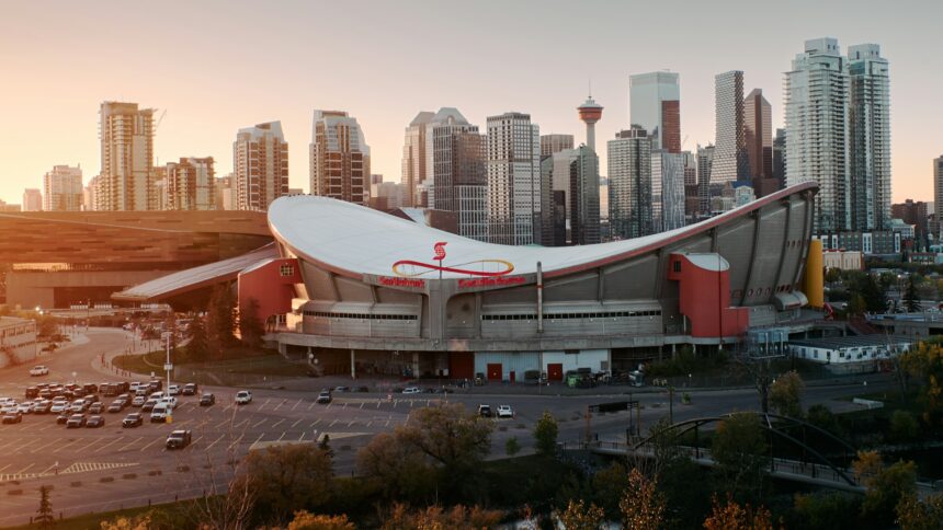 Aerial view of the Scotiabank Saddledome curved roof with the Calgary skyline behind
