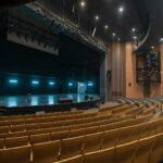 An empty theatre auditorium with rows of seats facing a stage