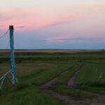 A power transmission tower on the prairie near Three Hills, Alberta at dusk