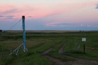 A power transmission tower on the prairie near Three Hills, Alberta at dusk