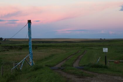 A power transmission tower on the prairie near Three Hills, Alberta at dusk