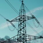High voltage transmission towers carrying lines across open country